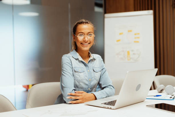 istock Smiling employee in office with laptop 1407718772