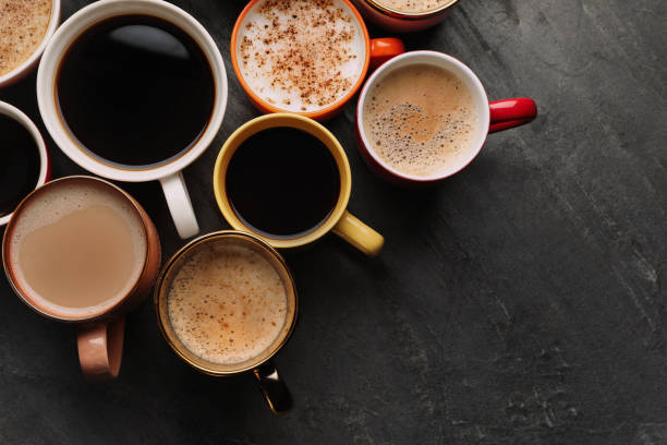 istock Many cups of different coffees on slate table, flat lay. Space for text 1407720882