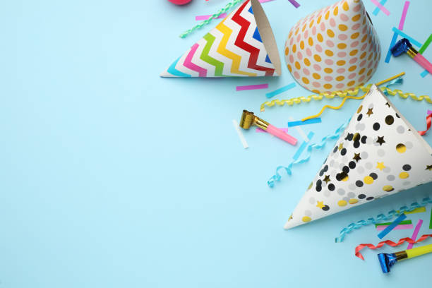 istock Flat lay composition with party hats and other festive items on light blue background. Space for text 1407722122