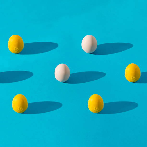 istock egg yolk and whole egg pattern on blue background with long shadows. Healthy food concept, square composition with copy space. 1407722377