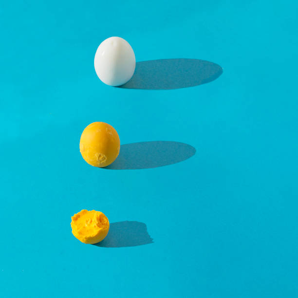 istock Egg white and whole and semi eaten yolk in row with long shadow on blue background. Square composition with copy space. Healthy breakfast concept. 1407722417