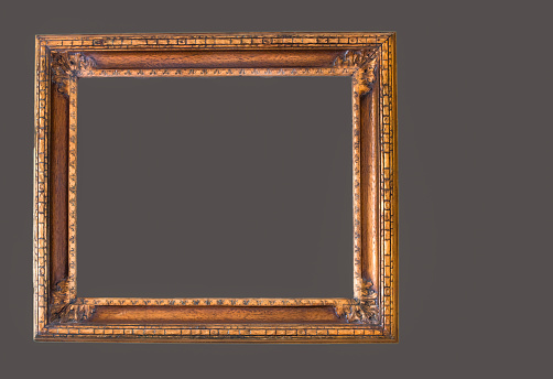 Antique gilded wood picture frame on a dark gray background