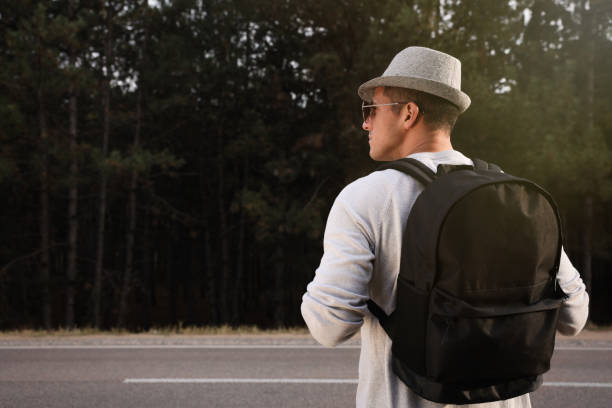 Free Stock Photo of Man With Hat and Backpack Looking at Road ...