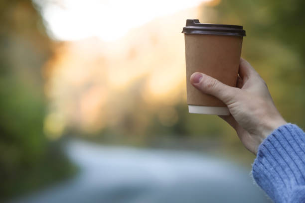 istock Woman holding takeaway coffee cup outdoors, closeup. Space for text 1407722811