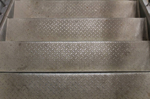 full frame background of wet iron grate stairs in diagonal perspective composition.