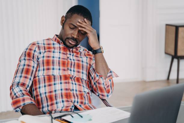istock Tired african american man suffer headache at laptop thinking about business problem. Stress at work 1407723603