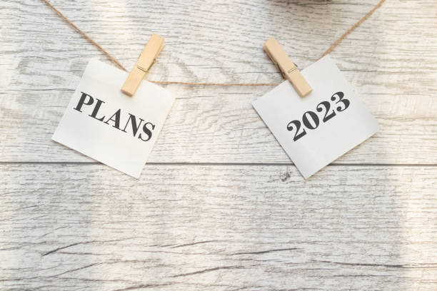 the plan for 2023 is held on clothespins. wooden background - white personal organizer calendar speech imagens e fotografias de stock