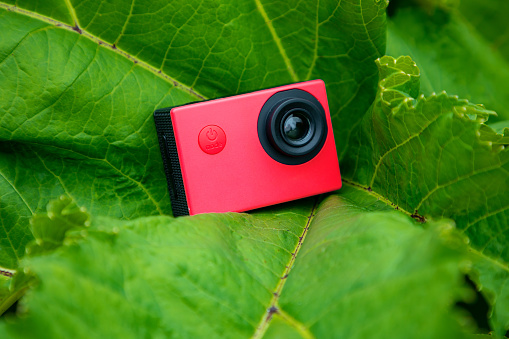 Action camera on a green background on a sunny day.