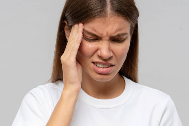 istock Young woman suffering from headache, isolated on gray background 1407724932
