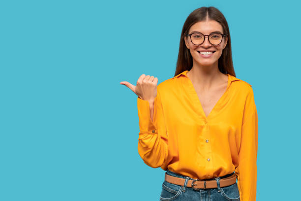 istock Young woman pointing to the side, showing copy space for offer 1407724953