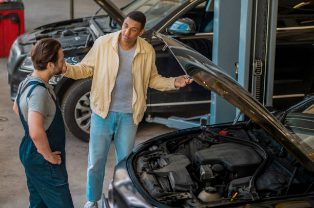 istock Technician in car service talking to the client 1407724993