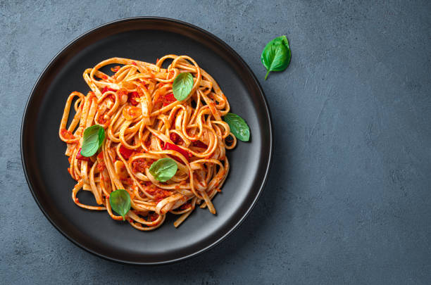istock A portion of linguini pasta with classic tomato sauce on a dark graphite background. 1407726037