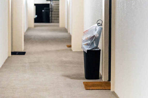 Concierge valet door to door trash collection services for apartment with garbage in bin and plastic bags for pick up in residential building hallway corridor hall stock photo