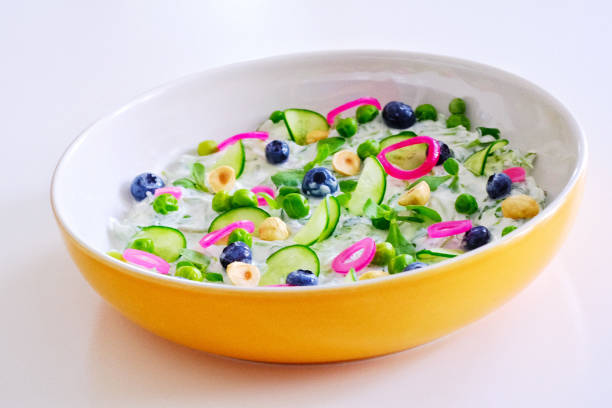 purslane and yoghurt salad with blueberries, cucumbers, pickled onions, peas and hazelnuts