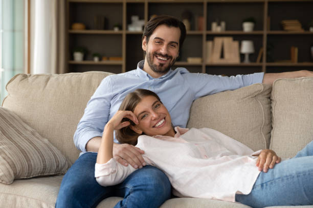 istock Happy spouses relaxing on sofa smile look at camera 1407729978