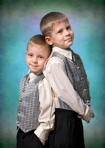 Vintage black and white image from the sixties, a little boy and a little girl posing together smiling at the camera