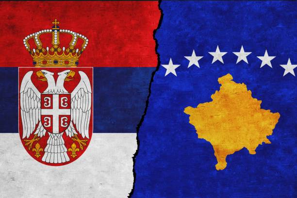 istock Kosovo and Serbia painted flags on a wall with a crack 1407730845