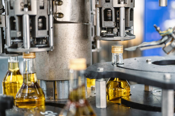 istock Automatic equipment puts caps on alcohol beverage bottles 1407730909