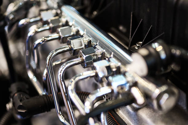 Thin shiny silver pipes of high pressure pump of contemporary powerful diesel engine in plant workshop extreme close view