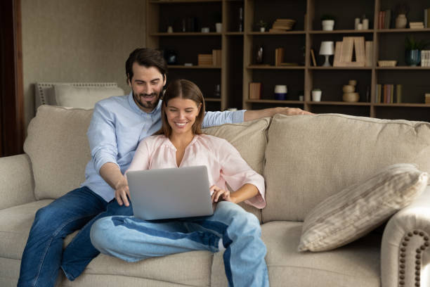 istock Married couple sit on cozy sofa with laptop 1407731022