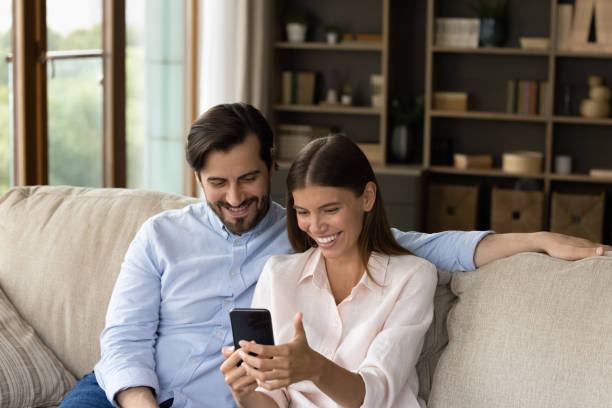 istock Couple looking at cellphone screen enjoy conversation using video call 1407731026