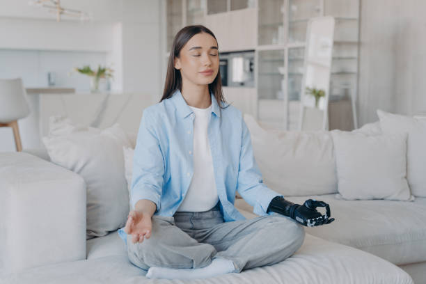 istock Tranquil disabled woman is sitting in lotus pose. Modern artificial limb with sensor control. 1407731931