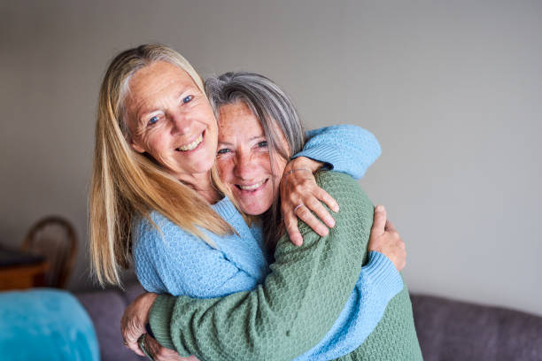 istock Smiling mature sisters embracing each other 1407731985