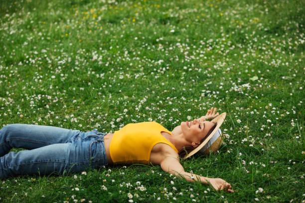 istock Smiling young woman lying on grass 1407737315