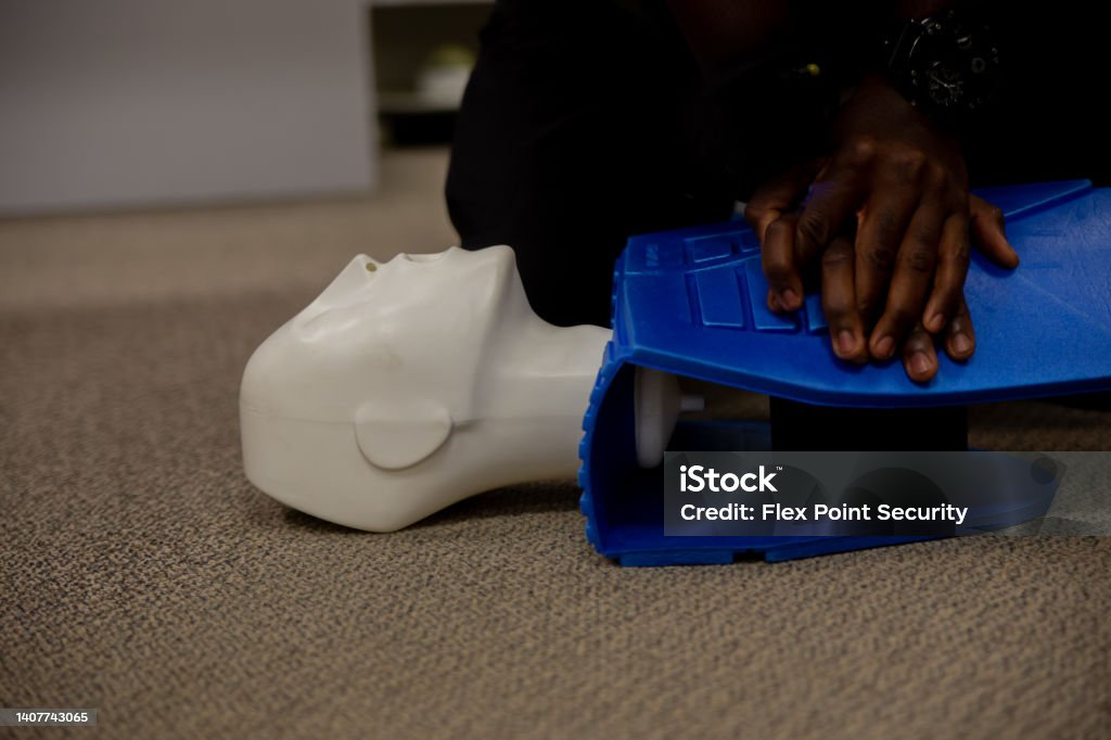 Security guard training for  CPR first aid with the AED. Security guard conducting CPR first aid with the AED. CPR Stock Photo