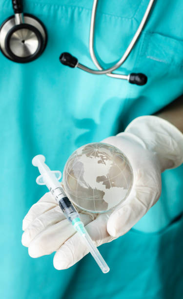 istock Doctor Holding Globe with Vaccine 1407744516