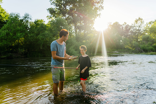 Photo of father and son fishing on the river