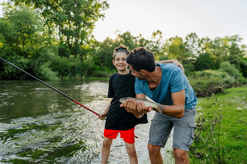 Photo of father and son fishing on the river
