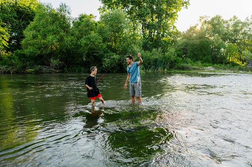 Photo of father and son fishing on the river