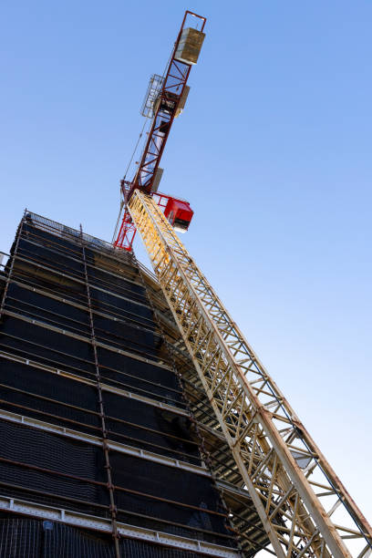istock Tower crane at construction site against blue sky background with copy space 1407745351