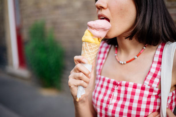 istock Beautiful woman eating ice cream 1407745370