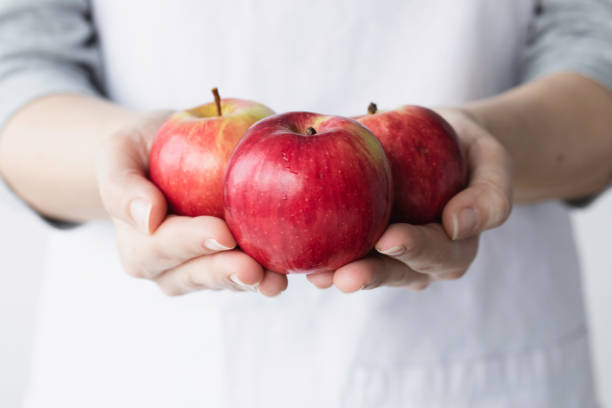 Young woman holding red apples.