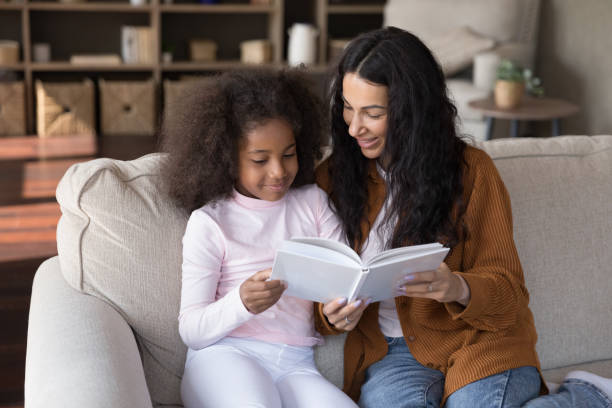 istock Happy positive mom teaching kid to read, holding open book 1407748413