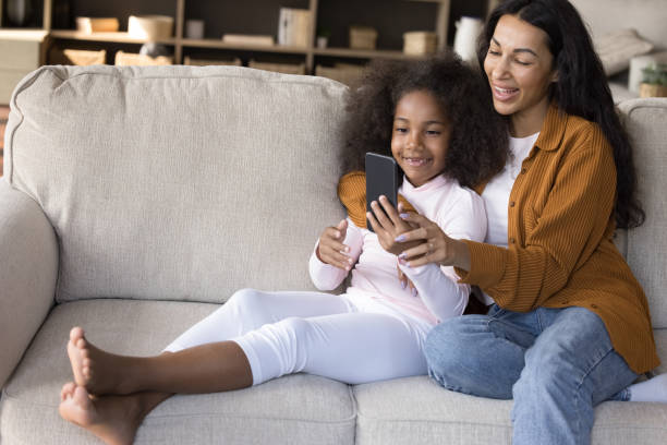 istock Happy young mom and kid making video call on smartphone 1407748427