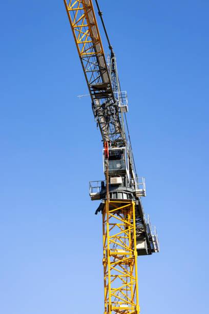 istock Closeup Tower crane at construction site against blue sky background with copy space 1407749273