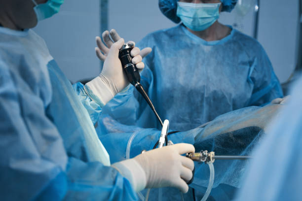 Gynecological treatment of the patient in surgery room Cropped photo of two doctors in surgical gowns standing near the patient and using hysteroscope urinary system stock pictures, royalty-free photos & images