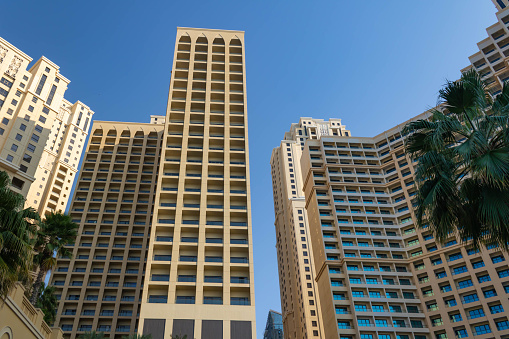 Sand coloured towers of Jumeirah Beach Residence, blue sky background