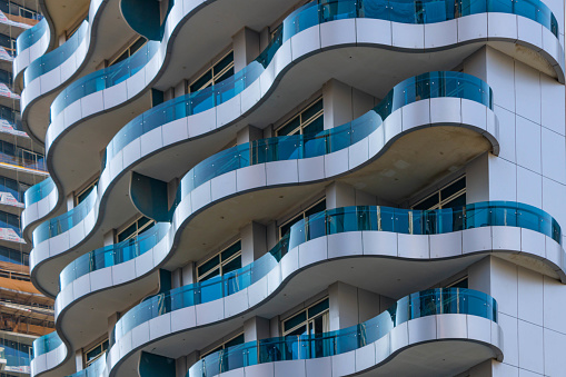 Close up of oval modern, glass balconies on modern buildings in Dubai, architecture backgrounds