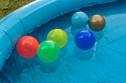 Colorful plastic balls in a blue children's pool, detail