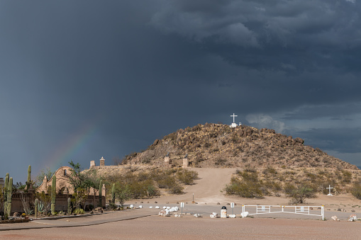 Dramatic sky and rainbow in Tucson, Arizona, near Mission San Xavier del Bac during monsoonal rainstorm