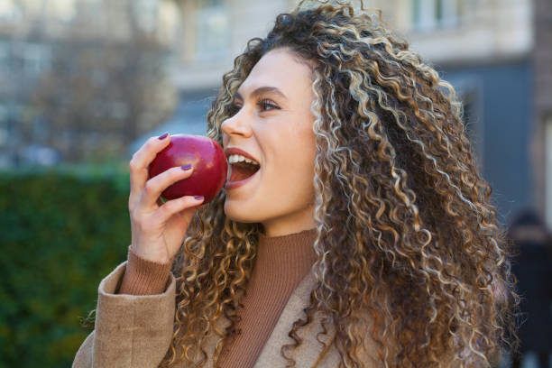 istock Young woman eating an apple 1407756418
