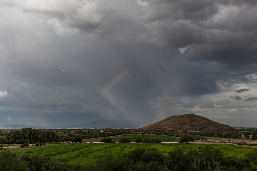 Dramatic sky and rainbow in Tucson, Arizona, near Mission San Xavier del Bac during monsoon season