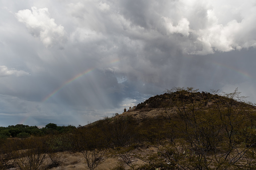 Dramatic sky and rainbow in Tucson, Arizona, near Mission San Xavier del Bac during monsoonal rainstorm