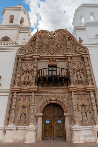 Facade of the San Xavier del Bac Mission in Tucson, Arizona, under dramatic monsoon sky