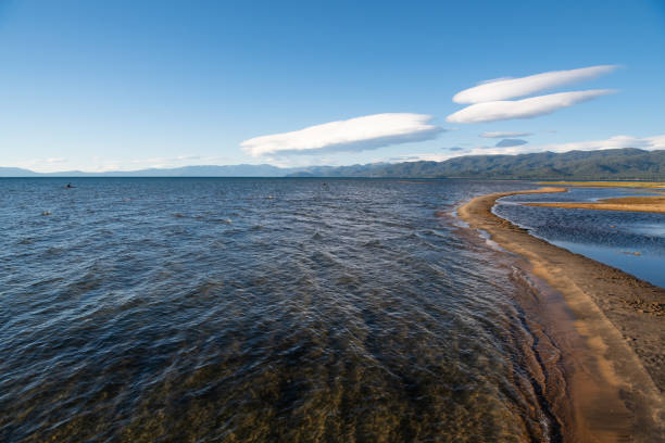 Sunset over the lake on a sunny summer day. Pebble beach.