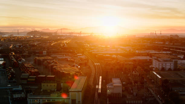 サンセットのオークランド港を通過する列車のドローンショット - oakland california commercial dock harbor california ストックフォトと画像